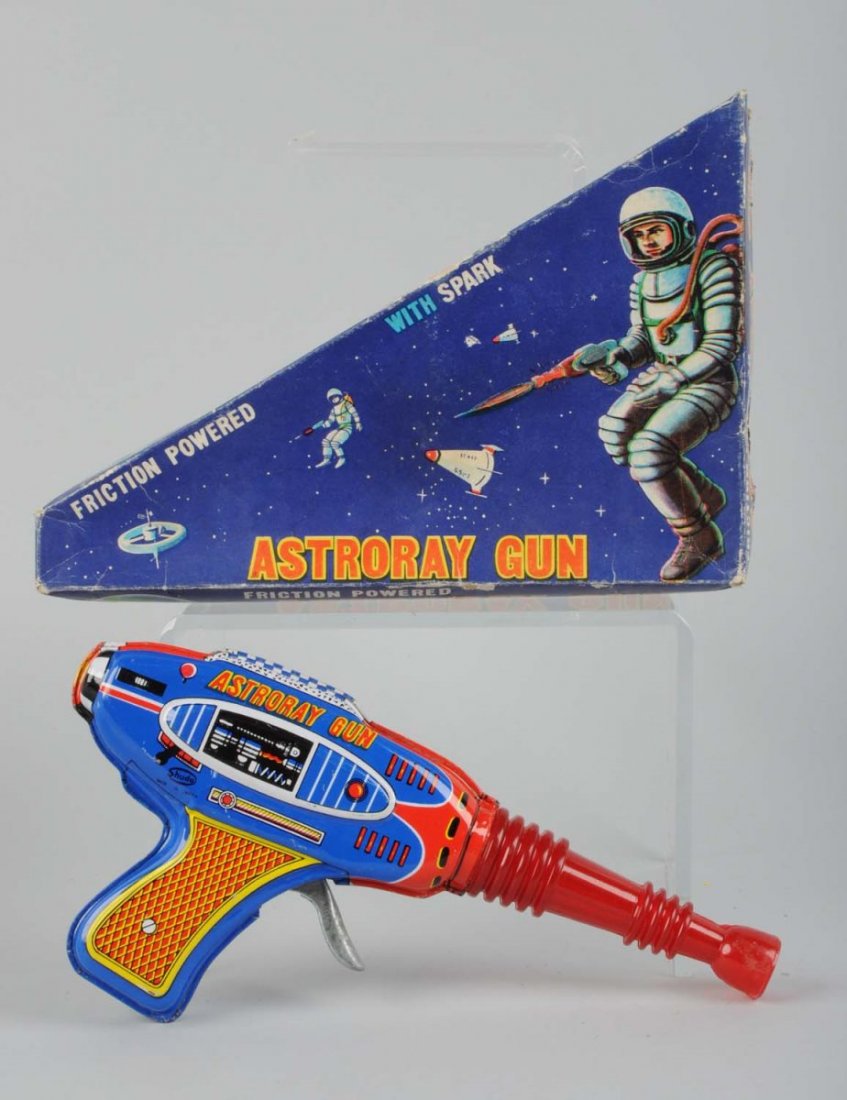 Tin Friction Astroray Gun In Original Box: Made by Shudo in Japan. Gun appears to be in pristine condition. It has a corrugated plastic barrel, tin body and handle. There are not visible scratches or chips to the tin litho. Original box has co