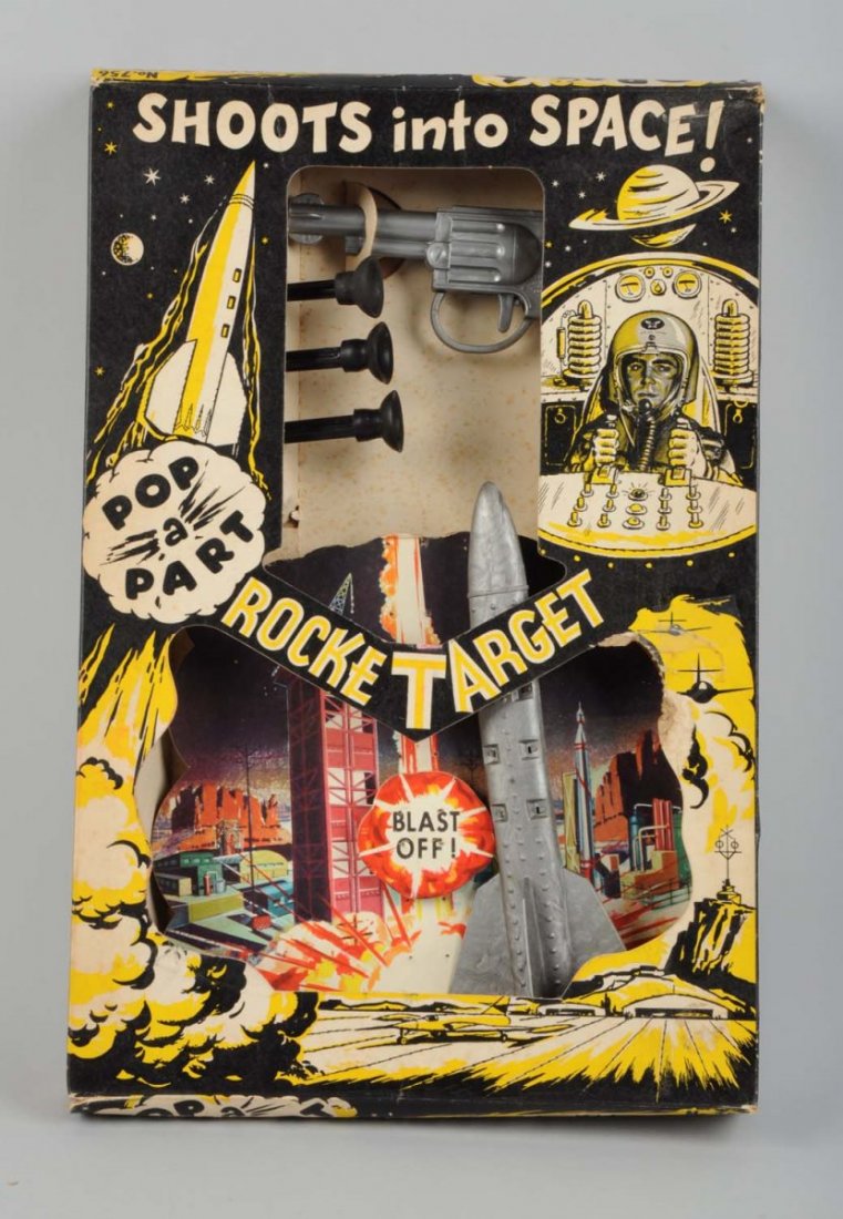 Rocket Target Set Game In Box.: Made by Knickerbocker in the USA. Game consists of spring-action gun, three rubber tipped darts, a cardboard section with graphics of buildings and space rockets, and one space rocket toy. Comes in or