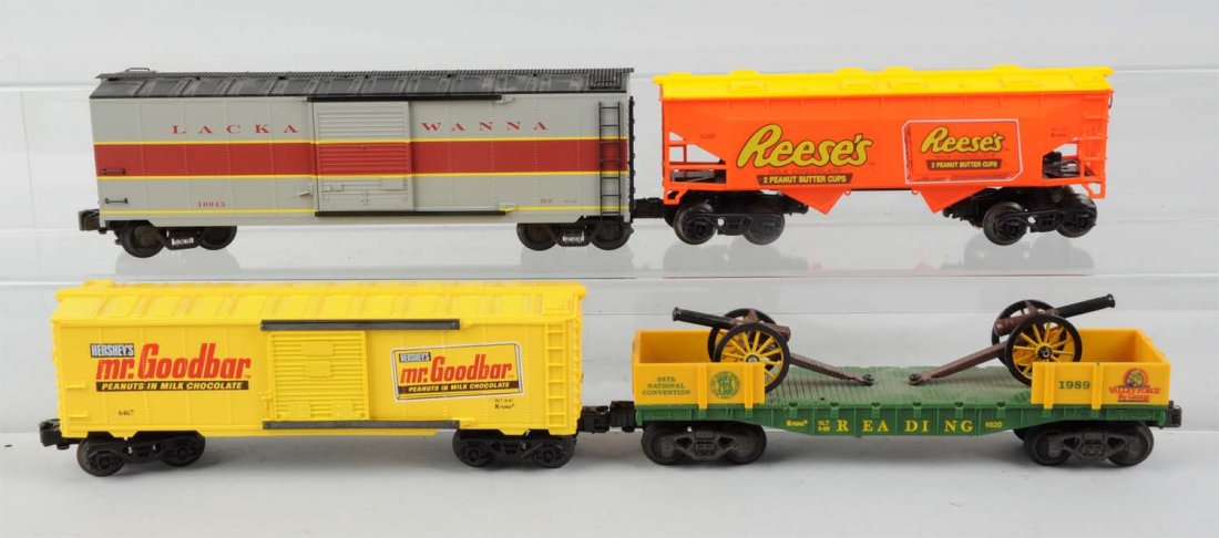 Lot of 4: K-line Assorted Freight Cars.: Lot includes: One K-line Reese's covered hopper. One Lackawanna box car. One Mr. Good Bar box car. One Reading flat car with cannon load from the 1989 TCA national convention. All cars are complete an