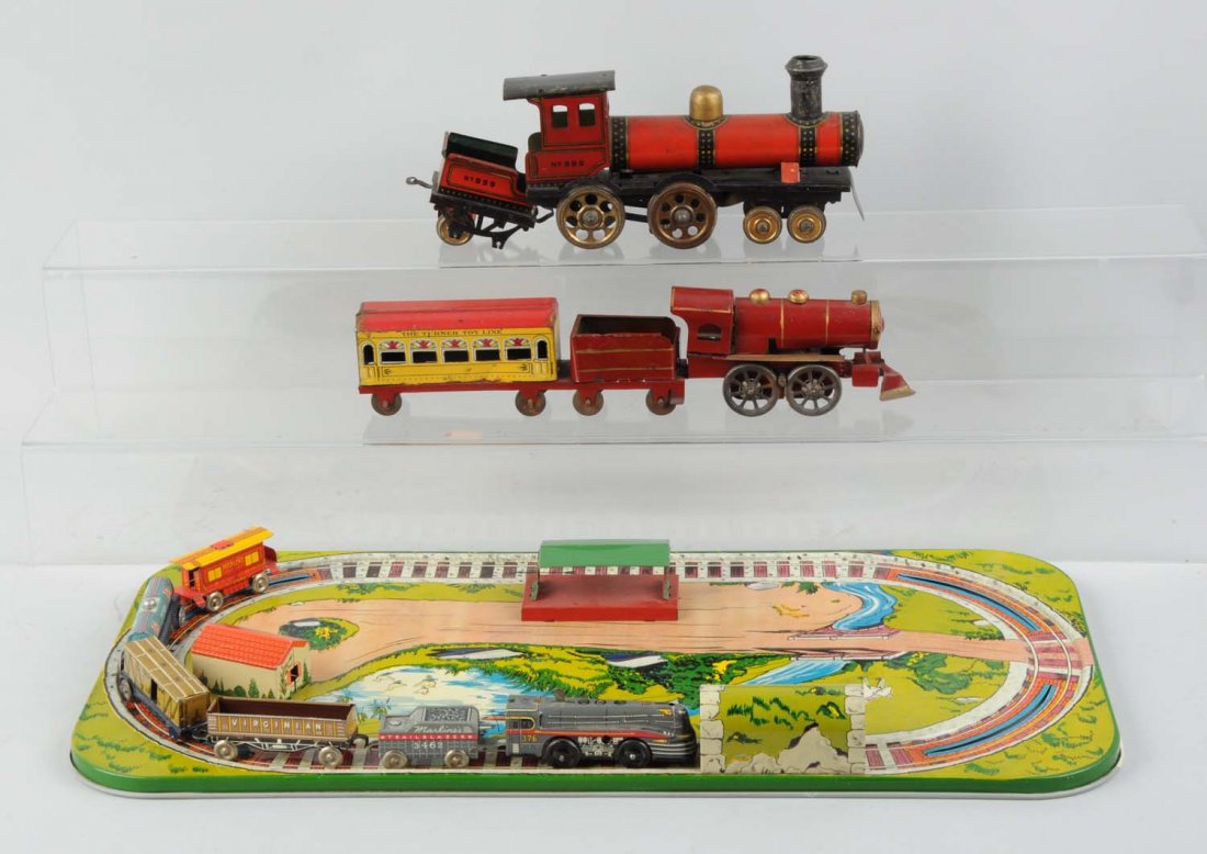 Grouping of Assorted Toy Trains.: Lot consists of one tin lithographed train platform for a channel-track train that is complete; an early wind-up red and black steam locomotive that is unmarked (as to maker) with some scratches and p
