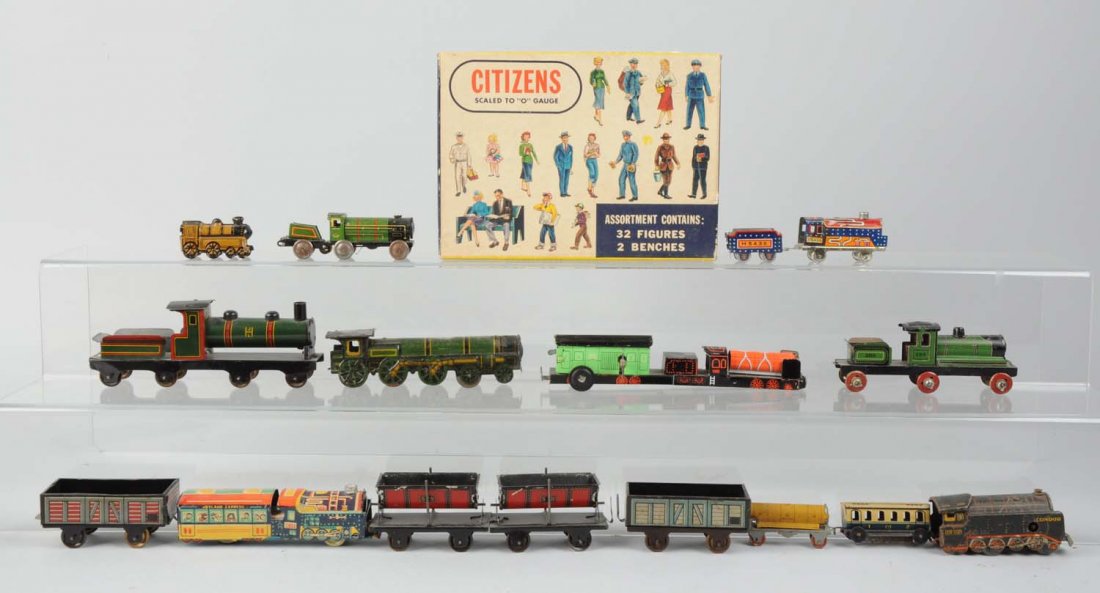 Large Lot of Penny Toy Size Trains.: Lot includes: small wind-up steam locomotive marked "Germany" condor with no key, some rust, scratches, paint chips, and alligatoring throughout; a very small passenger car that is blue and white with