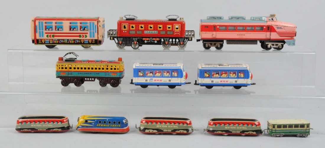 Lot of 11: Assorted Tin Litho Toy Trains.: Includes: Set of three NYC passenger cars, marked SAN Japan, all are complete and in excellent condition. One small friction train marked Atomic Train, has a few scratches but in very good condition.