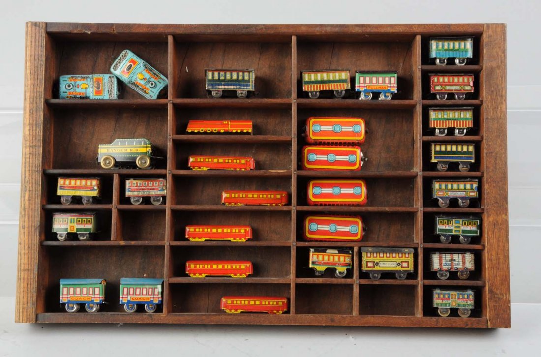 30 Tin Litho Small Toy Trains Wooden Display.: Includes: 30 Japanese tin and other makers tin litho toy trains, condition varies.