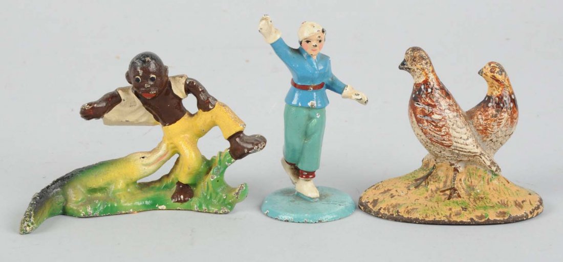 Lot Of 3: Paper Weights & Bottle Openers.: Vintage cast iron paper weights and bottle openers. One is a bottle opener of an African American man trying to escape and alligator, one is a woman ice skating, and one that looks like two pheasants,
