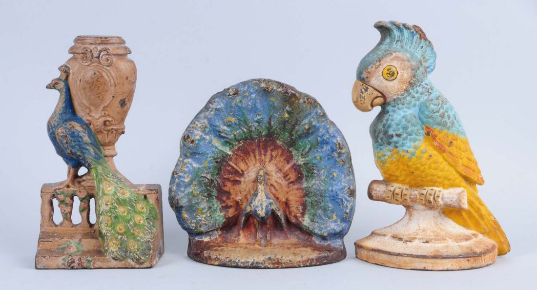 Lot of 3: Cast Iron Assorted Doorstops.: Includes: peacock by urn, Hubley; peacock, Albany; Polly parrot, Hubley. Condition (Very Good). Size Largest: 8 - 1/8" T.