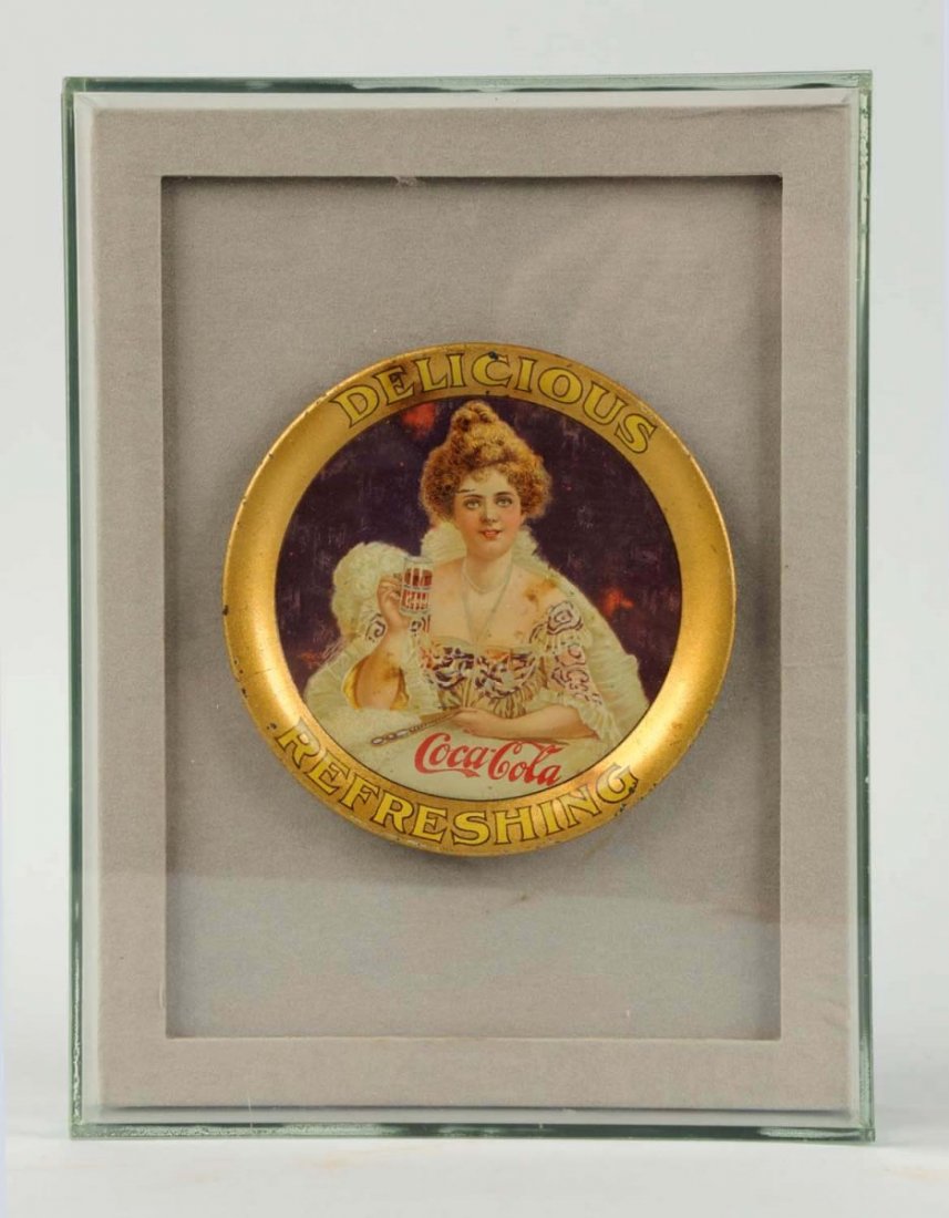 1903 Coca-Cola Change Tray.: Mounted in a nice showcase frame assembly. The tray displays well with just a few small color nicks or marks on the face with a few more spots and marks on the outer rim. Small stain at 11 o’clock n