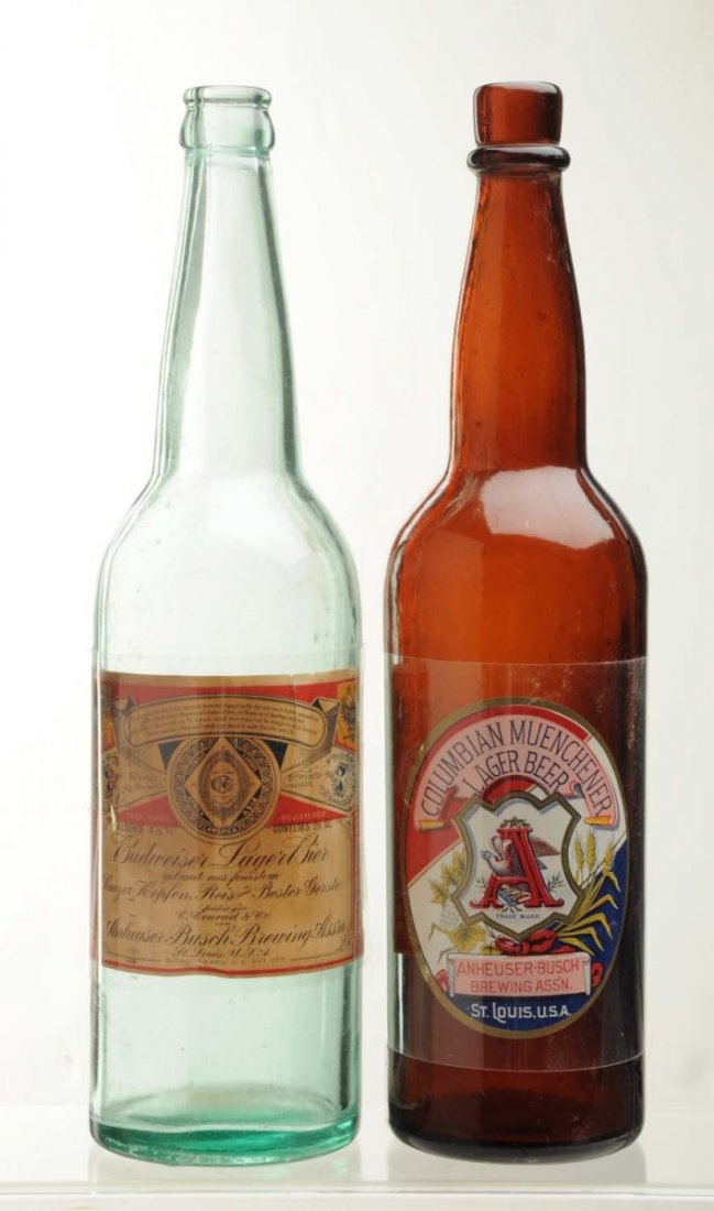 Lot Of 2: Anheuser-Busch Beer Bottles.: Pre-Prohibition. This lot includes a large bottle with a Budweiser Lager Beer label with minor wear and some staining, and another large bottle with an Anheuser-Busch Columbian Muenchener Lager Beer l