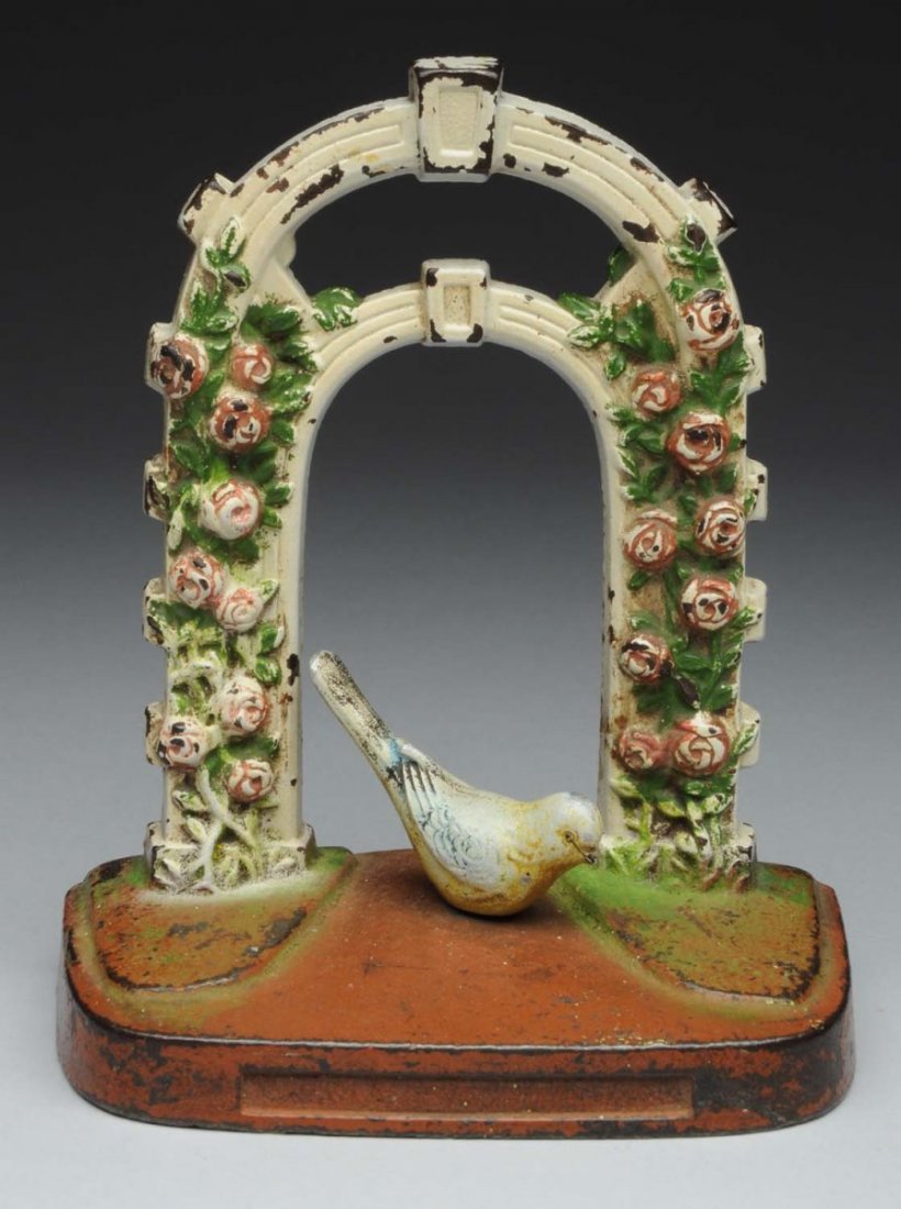 Cast Iron Rose Trellis With Bird Doorstop.: Judd Company, “cjo”. Depiction of pink roses embossed on trellis with yellow finch on base, two piece casting. Condition (Excellent). Size 6 - 5/8" T.
