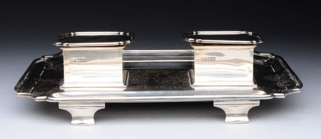 English Silver Inkstand.: Mappin & Webb, London 1915, in 18thC style with a shaped rectangular base with molded edges, two removable square-topped inkwells with glass wells, and a pen well on either side. Length: 10-1/4 in. Gr