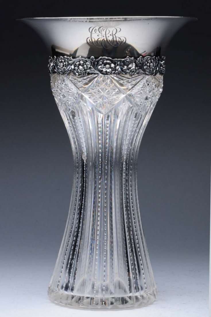 Tiffany Sterling Mounted Glass Vase.: 20thC, the glass body slightly concave and cut with sharp, serrated ribs, the sterling mount with a flaring plain rim and a band of scrolls and flowers below. Height: 12-1/2 in. - mark: post-1938 - so