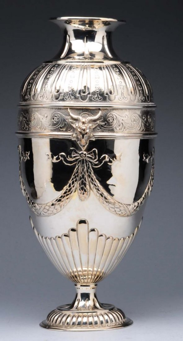 An English Silver Vase.: Harold Child, London probably 1906, the ovoid body chased with strapwork, a gadrooned base and a band of scrolls set with cast goat's heads above swags. Marks worn; marked on side with stamped under f