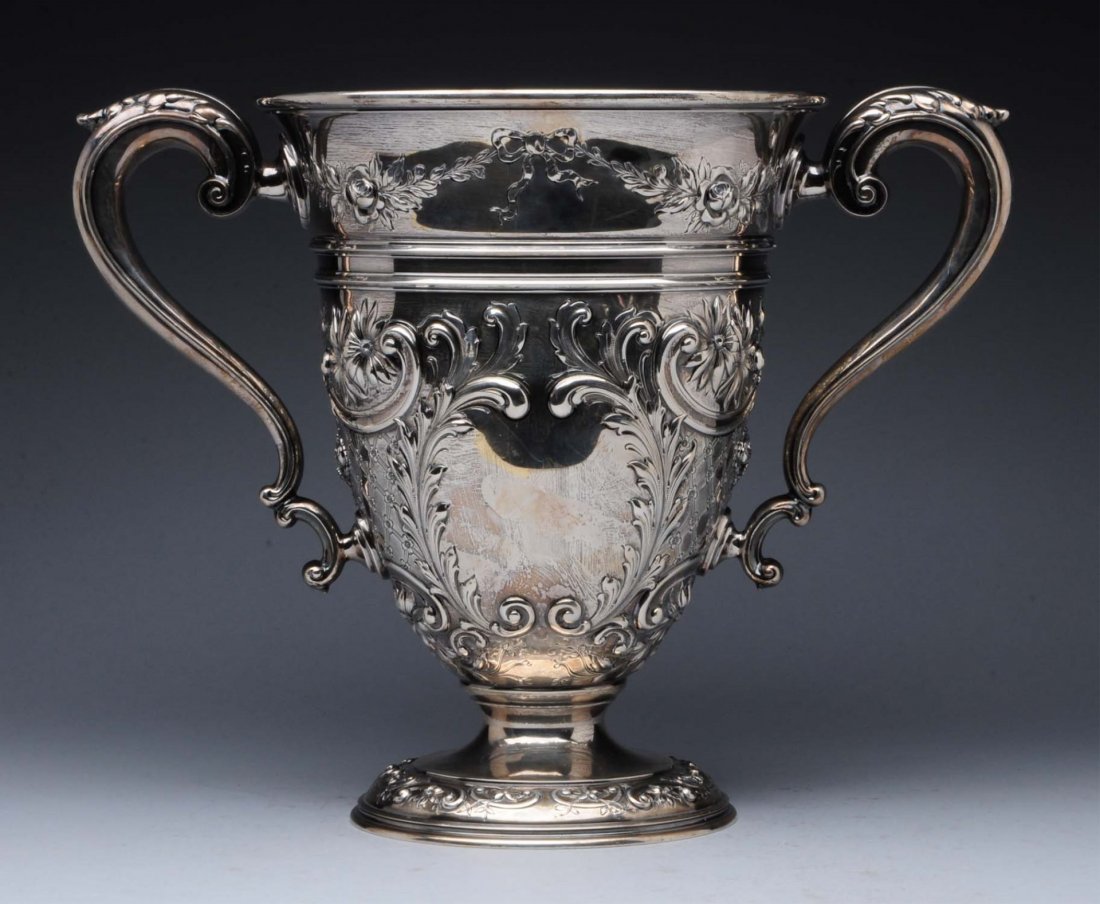 American Sterling Trophy Cup.: retailer's mark of Chester Billings & Son c. 1910, the body chased with scrolls and flower-heads around two vacant cartouches, each side with a leafage-capped scroll handle. Height: 10-3/4 in. Weight:
