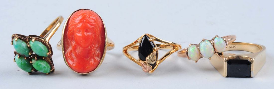 Lot Of 5: Assorted Gold Rings.: 14K stamped, with four green cabachons, abraded on top, size 7-3/4. 14K stamped ring with a dark blue emerald cut stone, chipped near corner, size 5-1/2. 10K tested ring with an orange carved face, si