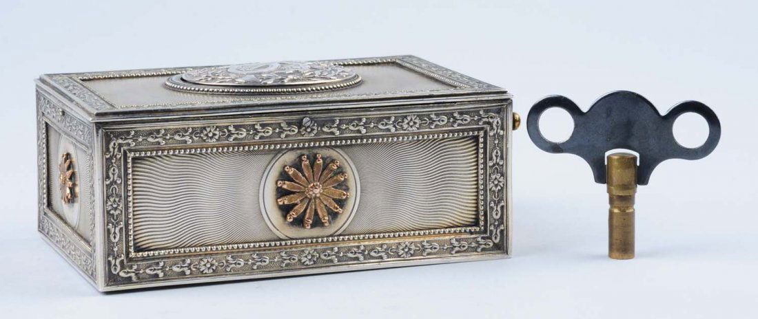 Rare Continental Silver Bird Music Box.: Embossed musical instruments. Plays well, no damage. Includes key. Condition (Excellent). Size 3 - 1/2" x 2" x 1 - 1/4".