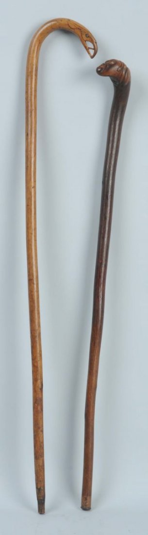 Pair of Folk Art Canes.: The first cane is an eagle head crook which could possibly be sailor made based upon the style of carving. It is dated 1887 and signed "Made by F.F. Thomas". The second is the knob handle has a face c