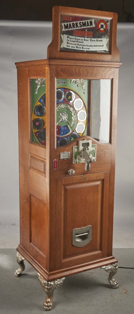 1 ¢ Ahrens The Marksman Shooter Arcade Game: English penny machine has pistol, which is loaded when player turns a knob. Prize is awarded for each bull's-eye. Includes keys. Beautiful machine! Condition (Excellent). Size 88" T.. CORRECTION: Work
