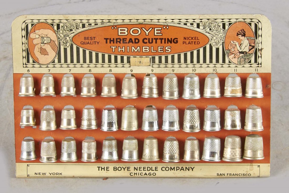 Boye Thread Cutting Thimble Display: Tin litho display with easel back and 36 thimbles. States; Nickel plated The Boye Needle Company New York Chicago San Francisco. Made by Shonk Works of Chicago. Circa 1920s. Condition (Very good). Siz