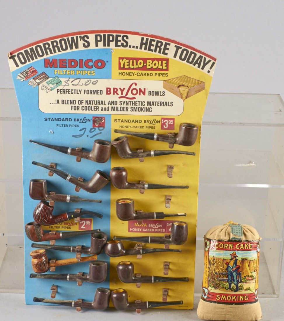 Medico Yelo-Bole Apollo Nova Tobacco Pipe Display: Includes one bag of Corn Cake Smoking Tobacco and 17 pipes. 15 seem to be new old stock. Designed to hang or use the easel back to display. "$2.00" is written twice on the display. Circa 1940s. Condit