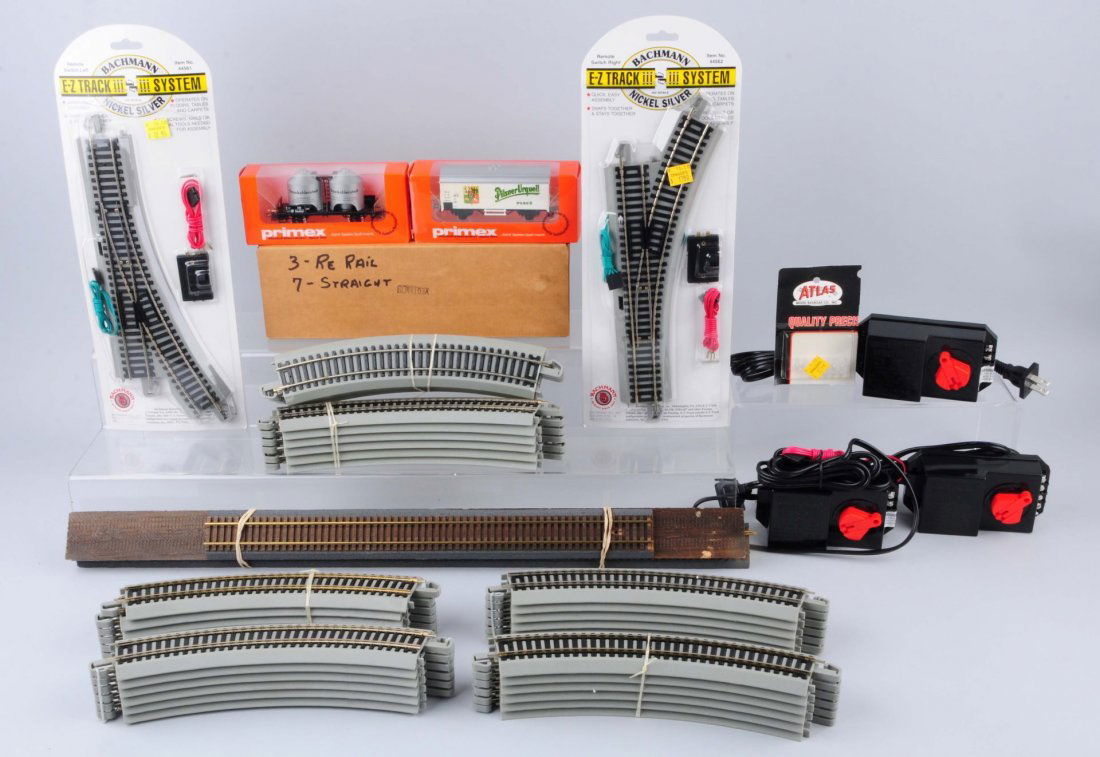 Large Grouping of Assorted Train Items.: Lot consists of two easy track switches. 25 easy track curves. Two Priemx black car with load 4511. 4553 beer car Pilsner Urquell complete like new and in original box. Few other odds and ends.