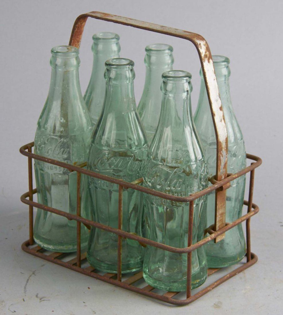 Six-Pack Of Glass Coca Cola Bottles: In a wire Each bottle is a Patent D style from a different city in Michigan- Detroit, Flint, Traverse City, Grand Rapids, etc. Condition (Good). Size 7-1/2" T