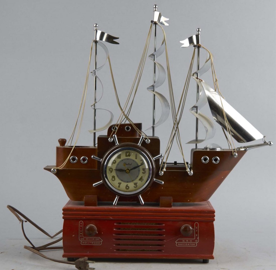 Figural Ship Clock Radio: Electric United Clock with AM radio housed in a model of a nine-sail ship. Condition (Very Good). Size 21" T.