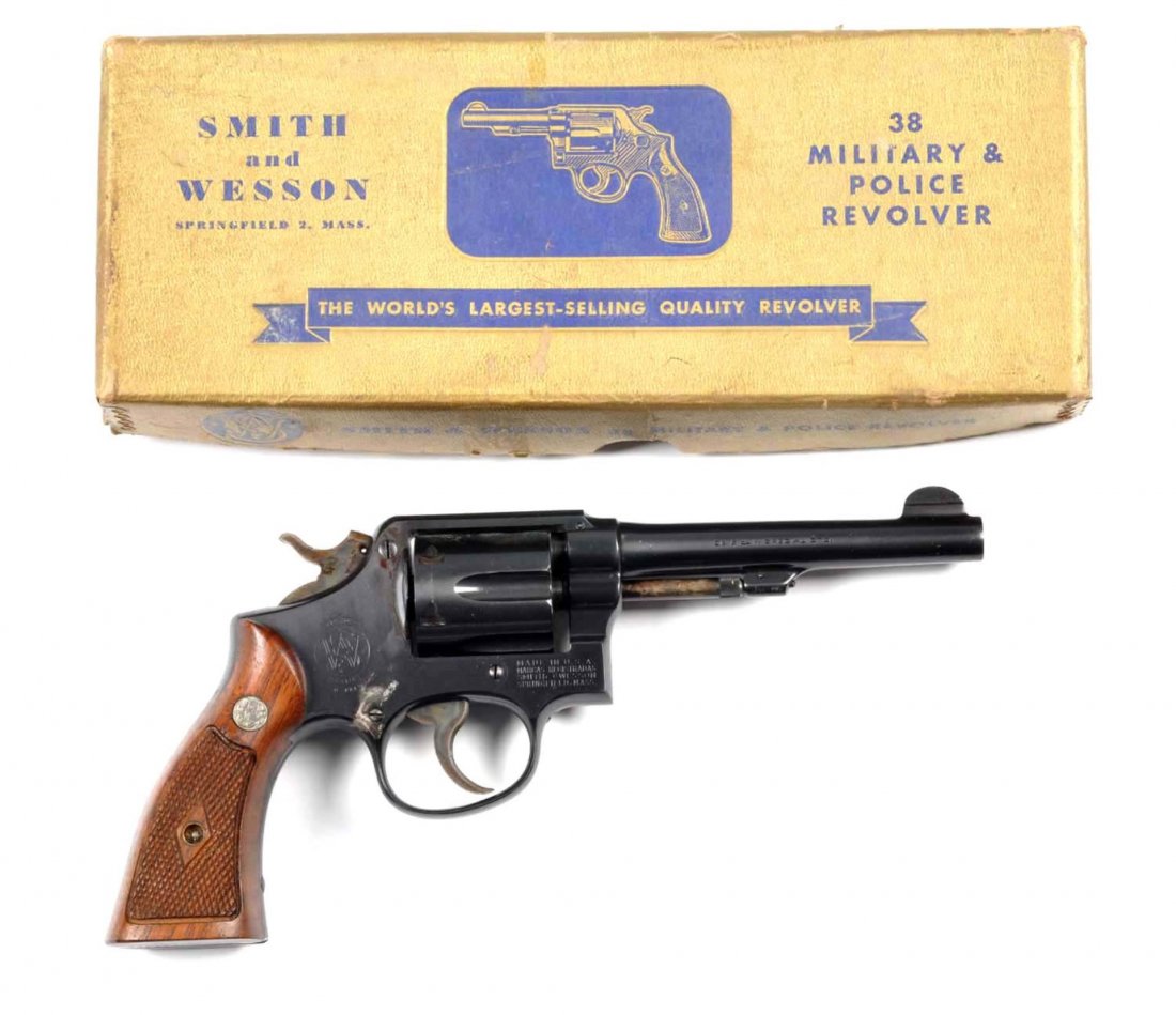 **Boxed S&W M&P Revolver.: Serial # C148350 Standard post-war M&P with 5" barrel, blued finish, six shot, double action, .38 Special, medallion walnut diamond grips, and case colored hammer and trigger. This gun has seen some u