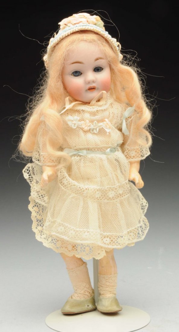 Petite Kestner Child Doll.: German bisque socket head incised “f made in Germany 2/0 143” with multistroked eyebrows, stationary eyes, painted lashes, open mouth with molded upper teeth, blonde mohair wig; original jointed c