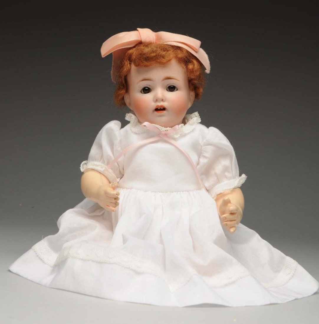 Pert Kestner Character Baby Doll.: German bisque socket head incised “made in Germany JDK 257”, stationary glass eyes, painted lashes, open mouth with two upper teeth and tongue, replaced auburn mohair wig; chubby composition baby 