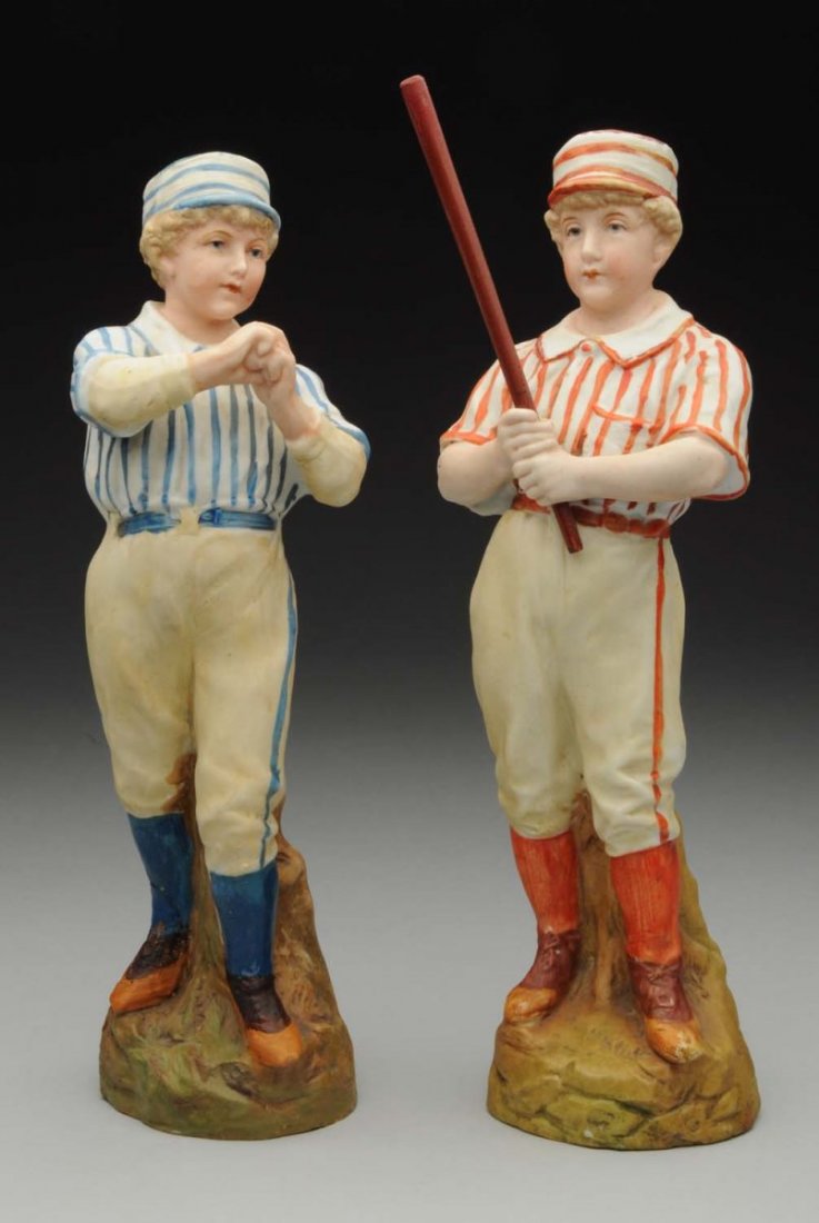 Pair of German Bisque Figurines.: Two boys playing ball, one holding a wooden bat, the other ready to throw the ball (the pitcher has a repair on one lower leg extending to the bottom of the figurine). Interesting sports themed figure