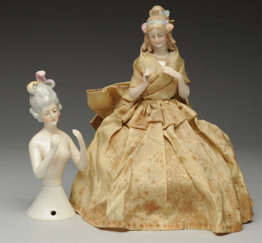 Lot Of 2: Porcelain Half Dolls.: Both are Goebel ladies, one with original “Jenny Lind 1810” label and flowers and ribbons in her hair; one with gray hair and pink plumes. Two beauties! Condition (Excellent). Size Largest: 5" T.