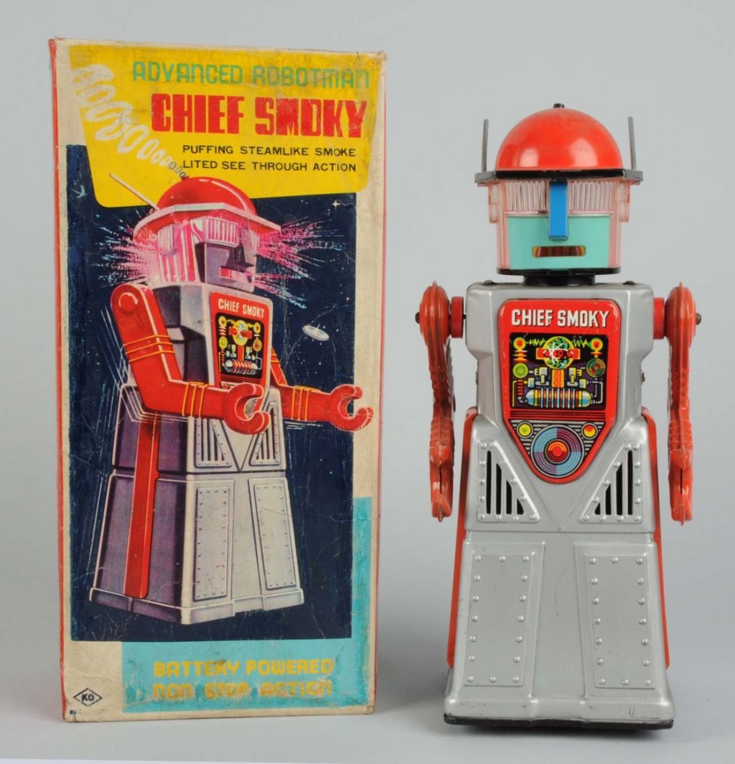 Japanese Tin Litho Chief Smoky Robot.: Battery - Operated. In original box. Made in Japan by Yoshiya. Box has moderate to heavy creasing. Robot itself has no cracks that come through, but in the back there are a small inner line cracks. So