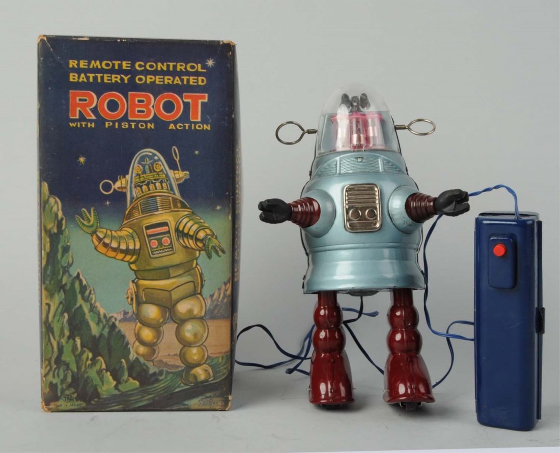 Japanese Tin Litho Piston Action Pug Robby Robot.: In original box. Made in Japan by Nomura. Remote control. Robot is very scarce blue color and has scarce litho box variation. Remote has some slight crazing on top part of battery case. Some minor to 