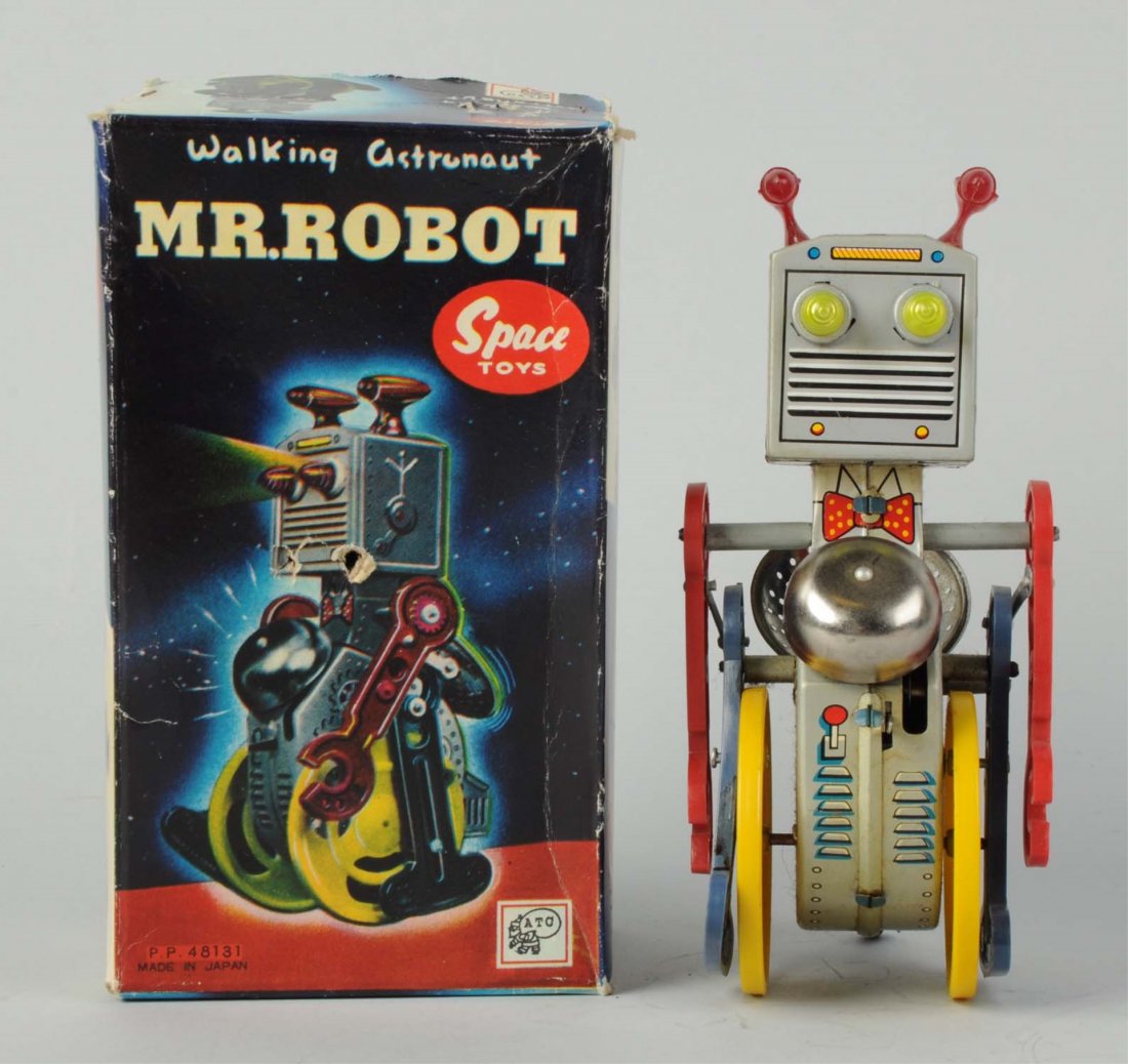 Japanese Tin Litho & Plastic Walking Mr. Robot.: In original box. Made in Japan by Asashi. Some creasing and wear throughout, two poke holes in the center of the front of the box and a small piece of paper litho missing on one end flap due to the re