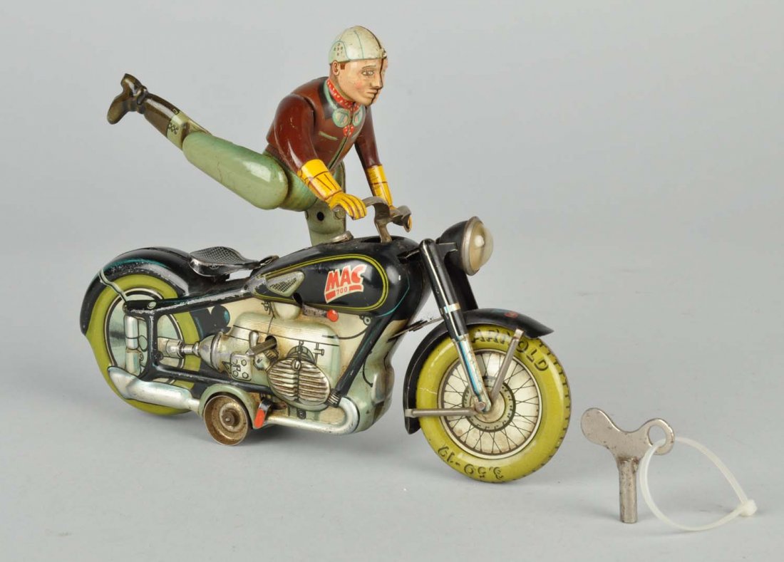 German Tin Litho Wind - Up Mac The Motorcyclist.: Marked "Mac 700" on both sides of gas tank. Made by Arnold Very nice toy with complicated mechanism. Made in U.S Zone Germany. Some scratching and wear. Original headlight. Toy runs but driver does no