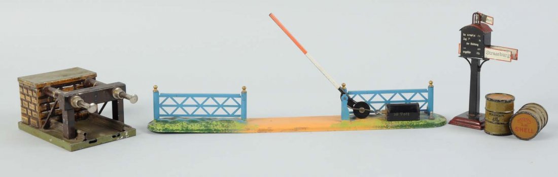 Assortment Of Marklin Accessories.: Lot includes one Marklin 1 gauge bumper, complete and all original, has scratches and paint chips throughout. Small train destination sign, two shell oil barrels, and a small electric operated crossin