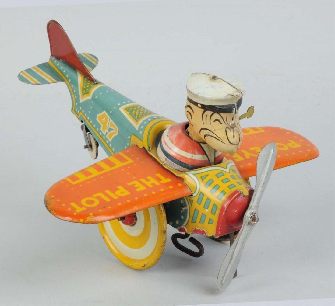 Marx Tin Litho Wind-Up Popeye The Pilot Toy.: 1936 version. Original pipe and tail fin. Some wear around Popeye's collar. Slight fading, scratching, and wear. Condition (Very Good). Size 9" L.