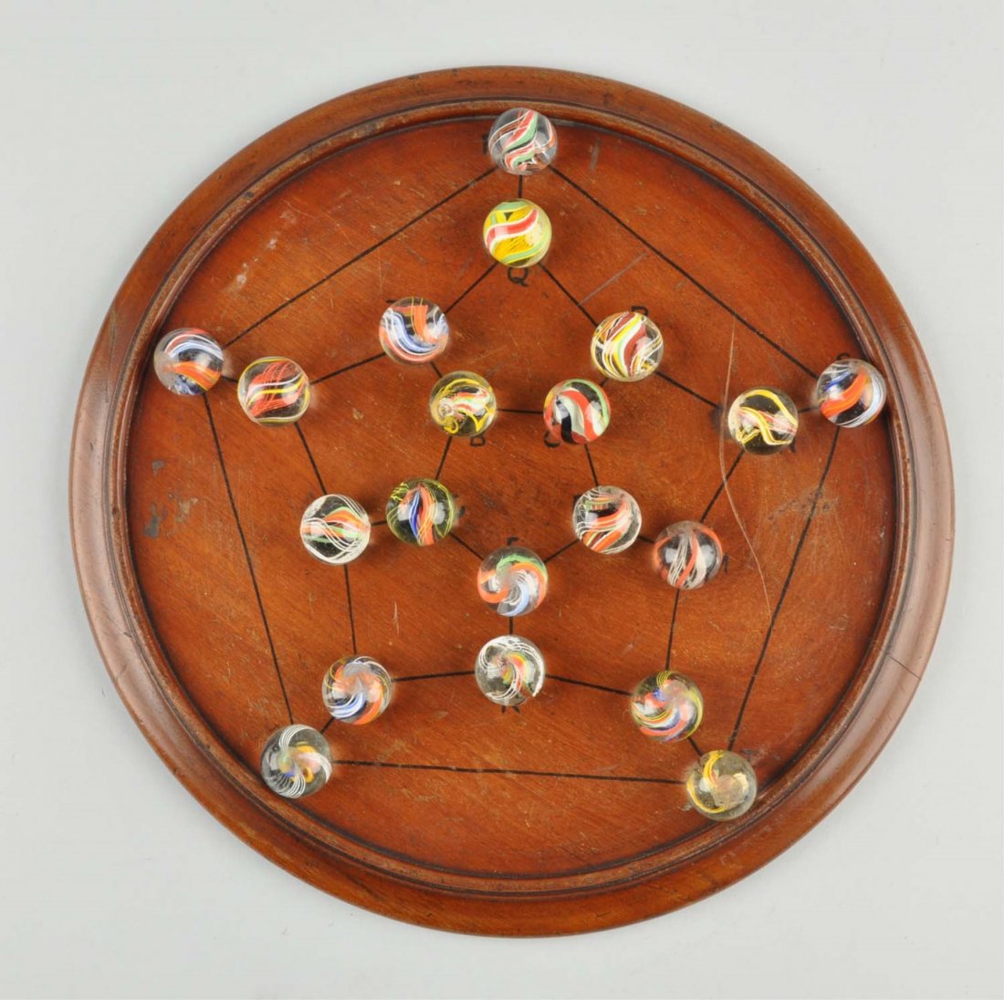 Marble Game Board with 20 Marbles.: Marbles: 7/8" Dia. Board: 11 - 1/2" Dia. Pentagonal marble board in mahogany wood with black enamel lines and letters. Marbles are bright English style which include divided core, latticino (including