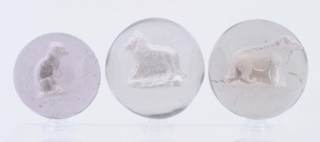 Lot Of 3: Sulphide Marbles.: The smallest is a sitting monkey with good detail and well centered. The second marble is a hyena with air bubble on lower body. The largest is a great figure of a standing lion. All three marbles are