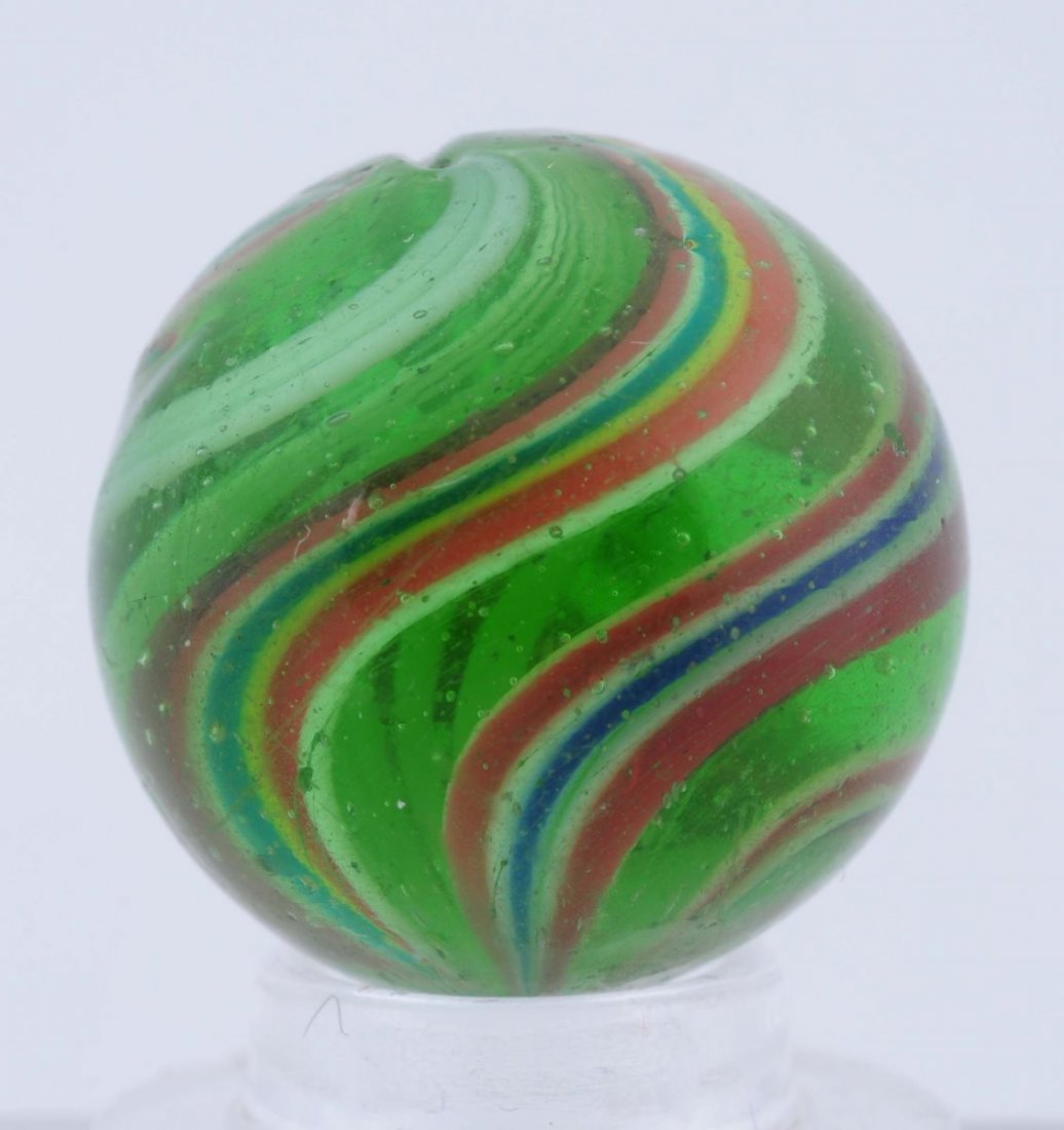 Green Glass Swirl Marble.: Hard to find green base white latticino core with outer bands combined red, white, and blue, and combined green, white, red, and yellow. Looks like it could be end of cane with some of the bands start