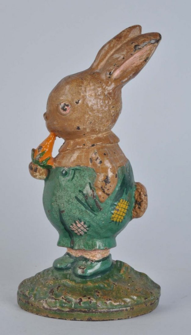 Cast Iron Peter Rabbit Doorstop.: Hubley, cat. No. 96, Grace G. Drayton design. Classic pose of Peter Rabbit eating carrot, with other paw in his overall pocket. Condition (Good). Size 9 - 3/8" T.