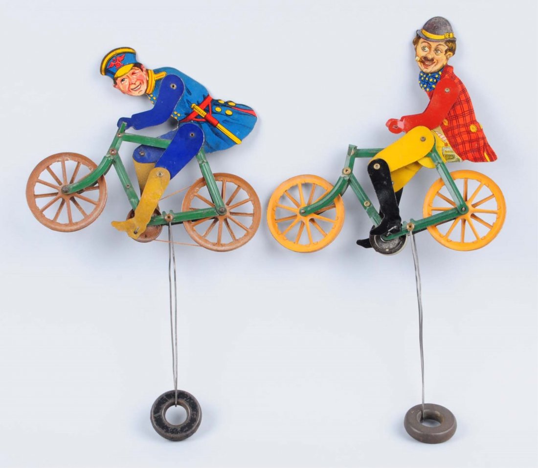 Lot Of 2: American Made Character Bicycle Toys.: These tin litho toys are weighted on the bottom, ran off of a wire. Circa 1920. Includes a police man, and a figure who looks somewhat like Charlie Chaplin. Nice litho, one scratch on bottom of police