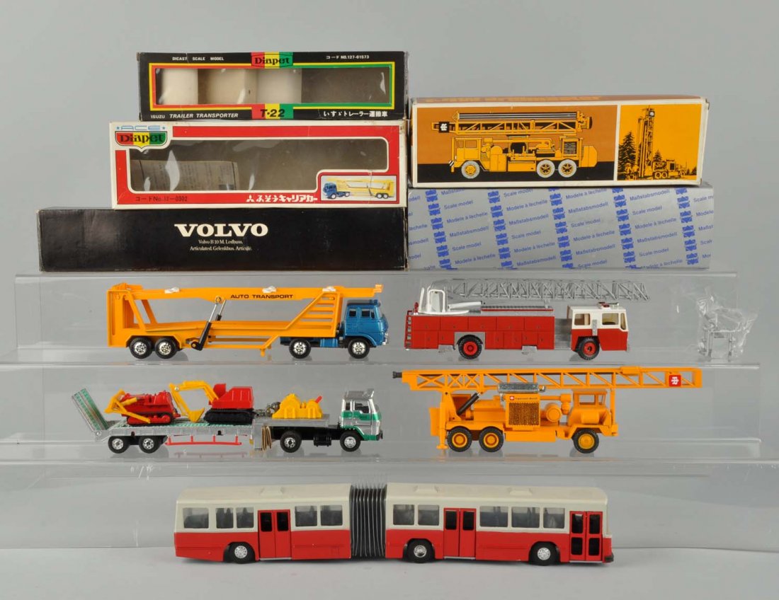 Lot Of 5: Die Cast Trucks And Various Vehicles.: Lot includes: two diecast trucks made in Japan, one is Isuzu trailer transporter, and the other one is an auto transport, does not come with vehicles. The other three are a Volvo bus, fire truck and a