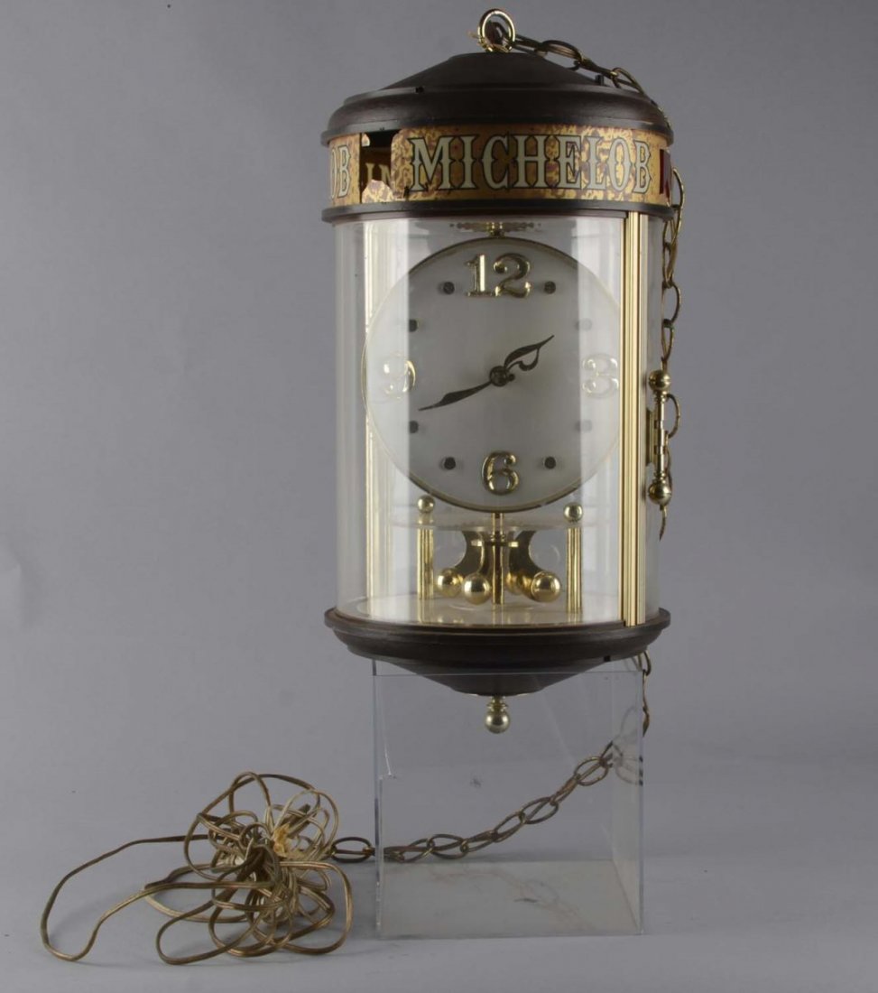 Michelob Beer Rotating Clock: Rotating clock with Anheuser Bush logo on the back includes attached chain and wiring for hanging. Top plastic reads "Michalob" and has a small missing section. Condition (Good). Size 23" T.