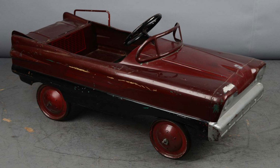Pressed Steel Child's Pedal Car: This burgundy and black pedal car features a functional trunk. Possibly an older restoration with a few areas of green paint coming through. Condition (Very Good). Size 39" x 19" x 16"