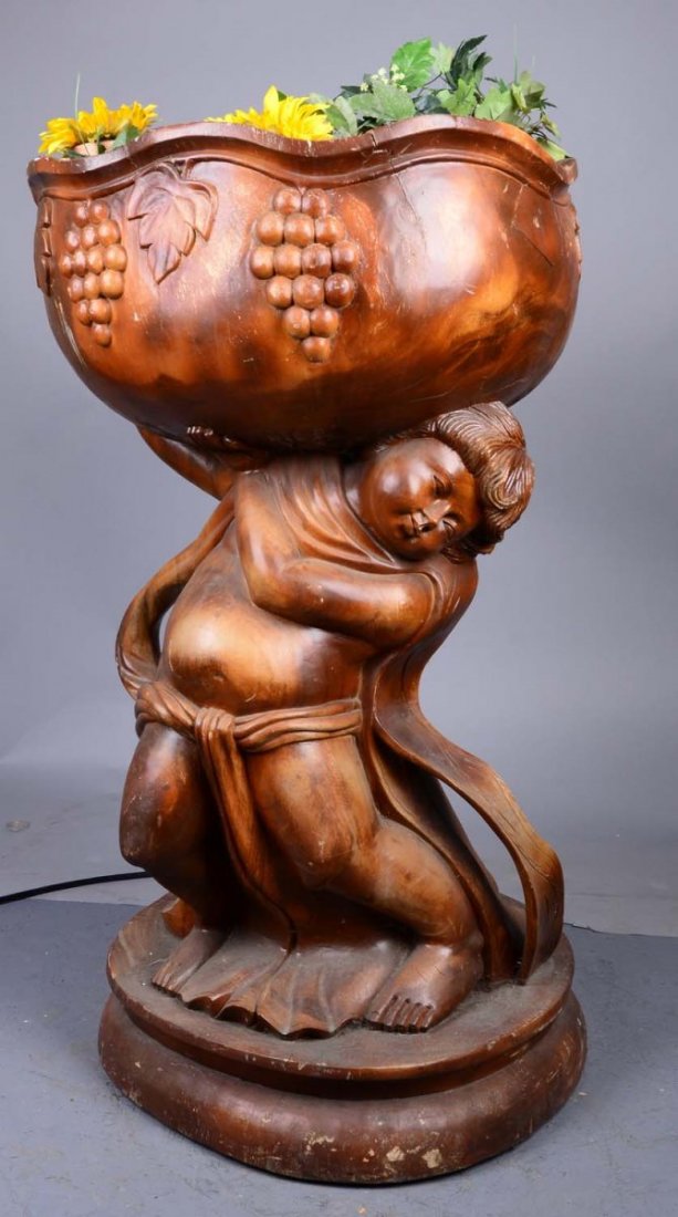 Tall Cherub Holding A Bowl Of Orange And Plants: This heavy piece looks like it was carved from a solid piece of wood. Came from a television and movie prop house. Condition (Good). Size 30" x 30" x 50"