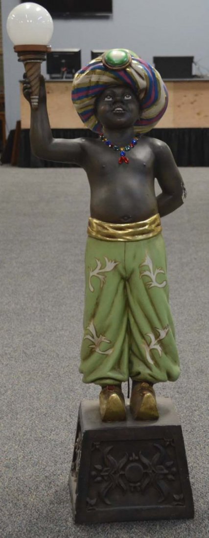 Egyptian Boy Statue Right Arm Holding Lamp Prop: This is a contemporary statue of a boy on stand wearing a jeweled necklace, turban and genie shoes. Has some damage to back of lower elbow. Used in "Supernatural 5" and "Mr. Young". Condition (Good). 