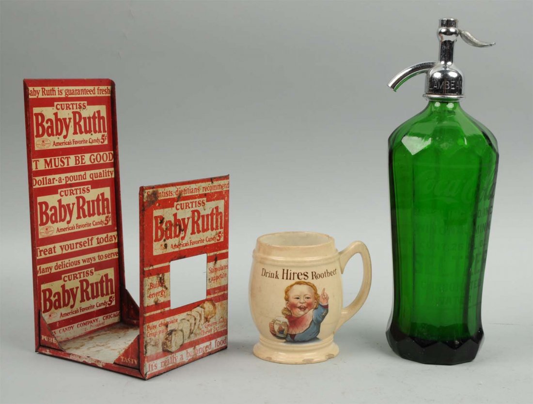 Lot Of 3: Advertising Items.: This lot includes a green Coca-Cola seltzer bottle, a Hires root beer mug with numerous chips and a Baby Ruth display rack with rest and dents. Condition (Very Good). Size Largest: 10" T.