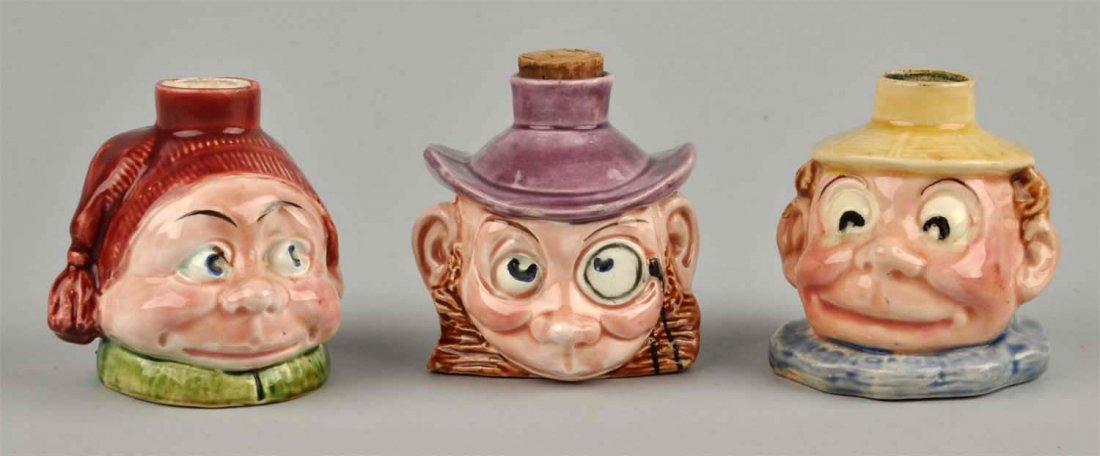 Lot Of 3: Comical Brownie-esque Flasks: Approx. 3” tall each flask depicts a comical face with such diversity that one cannot help to find these amusing. One flask still retains its original cork stopper and perhaps a slight scent of an a