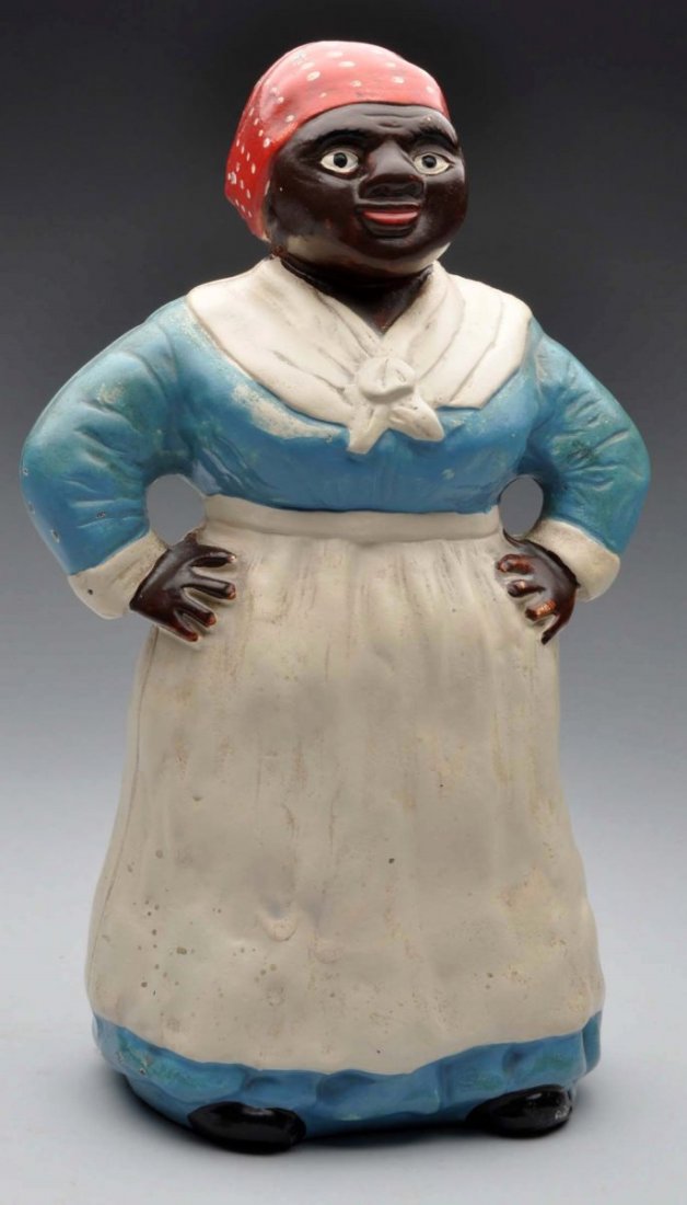 Cast Iron Southern Mammy W/ Hands On Hips Doorstop: Hubley. Depicts full-figure mammy with hands on hips wearing traditional apron and scarf. Blue dress paint variation. Condition (Excellent Plus). Size 12" T.