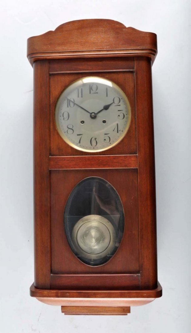 Walnut Wall Clock.: With a brass face. Time and strike. With pendulum and key. Condition (Excellent). Size 31" T.
